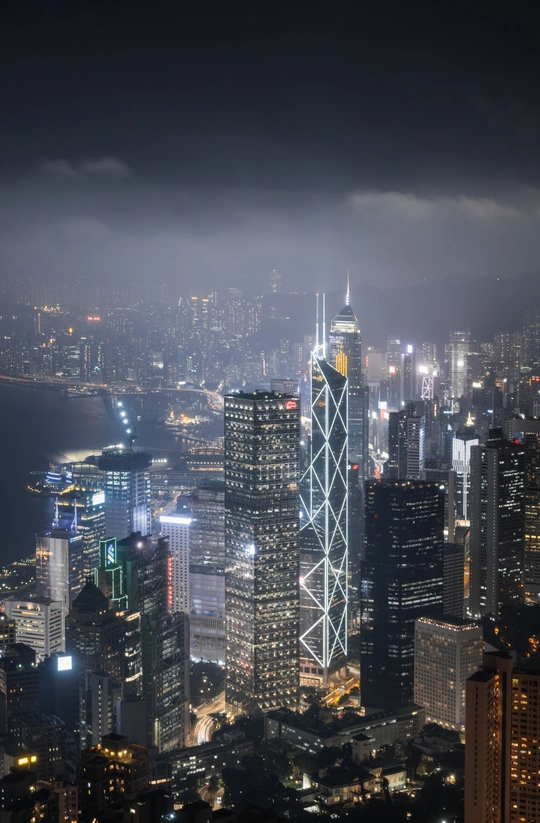 城市天际线在高层塔楼顶部亮起的夜景照片