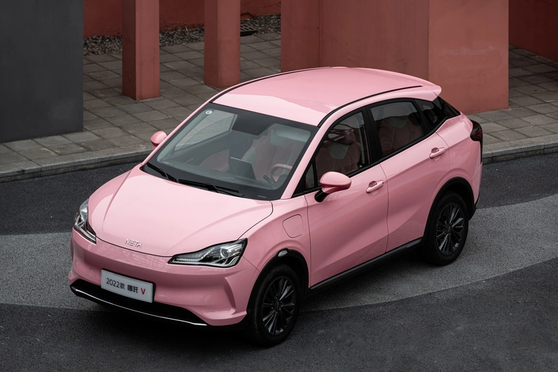 一个小粉红色汽车在摄影棚中展示。