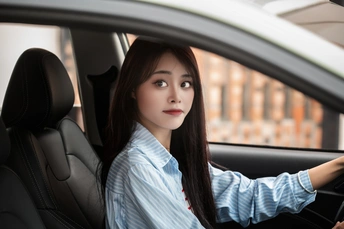 年轻女子开车 坐在驾驶座后面