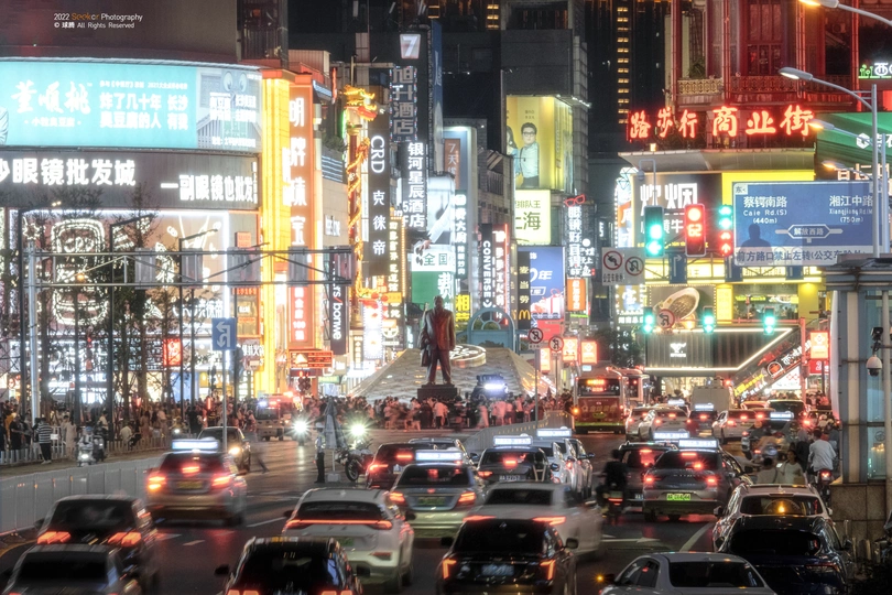 夜晚拥挤的城市街道 有许多标志、建筑和汽车。