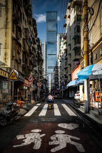 摩托车沿着高楼大厦旁边的街道行驶