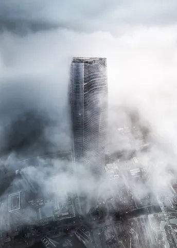 雾气缭绕的城市中一座高楼的图片