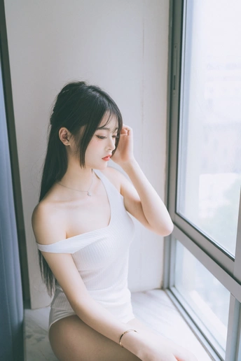 一个年轻女子坐在窗台上向外看