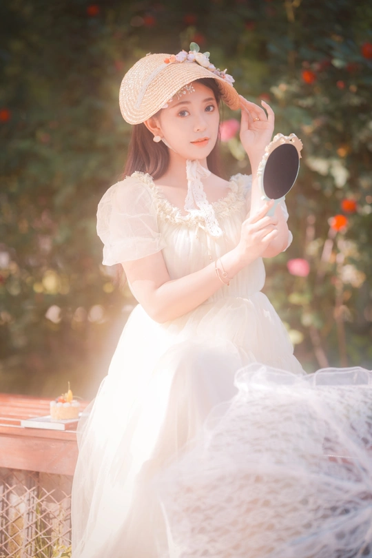 一个穿着白色连衣裙和帽子的小女孩
