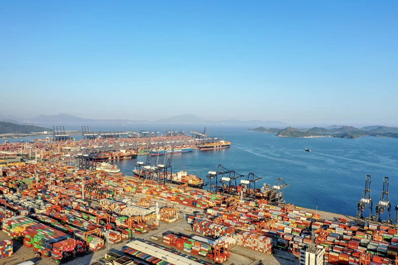 在一大片水域旁边的一个装满了许多集装箱的大港口