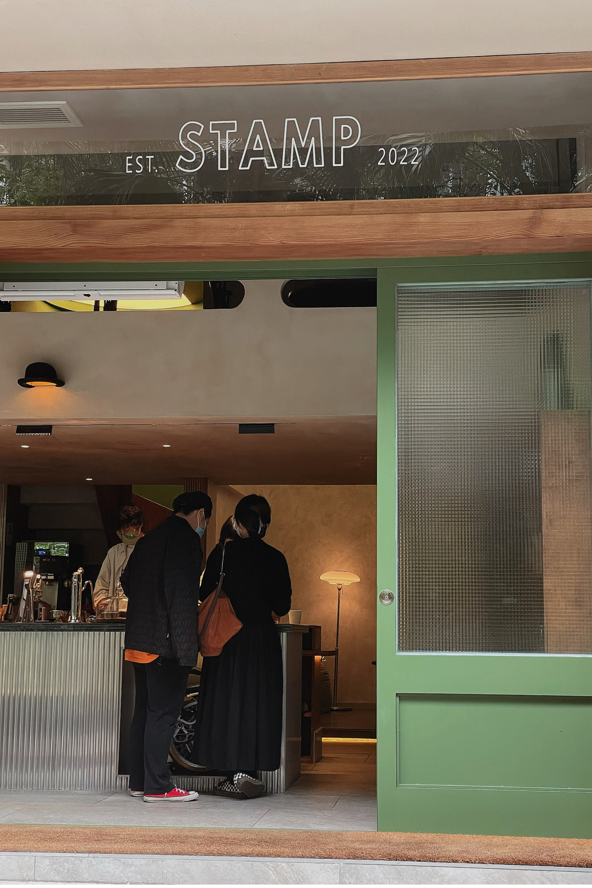一家餐厅的入口 绿色的门和站在柜台旁的人