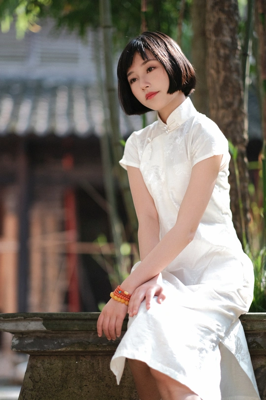 一个穿着白色短裙的年轻女子坐在长椅上