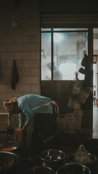 一个厨房里有几个锅和锅铲 一个人站在门口向外看窗户。