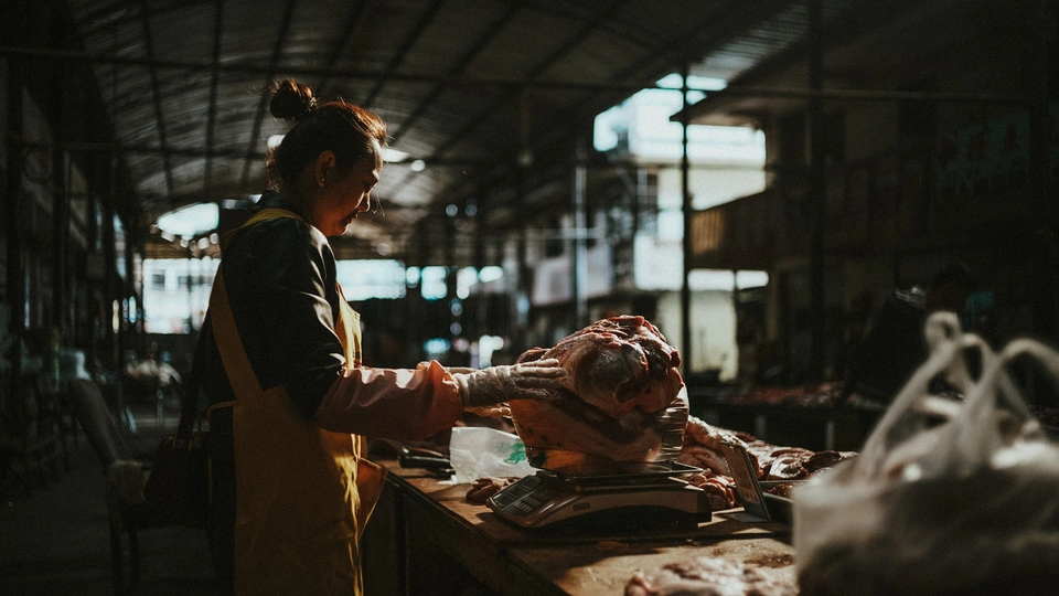 一个人站在一个有动物的桌子旁边的市场里