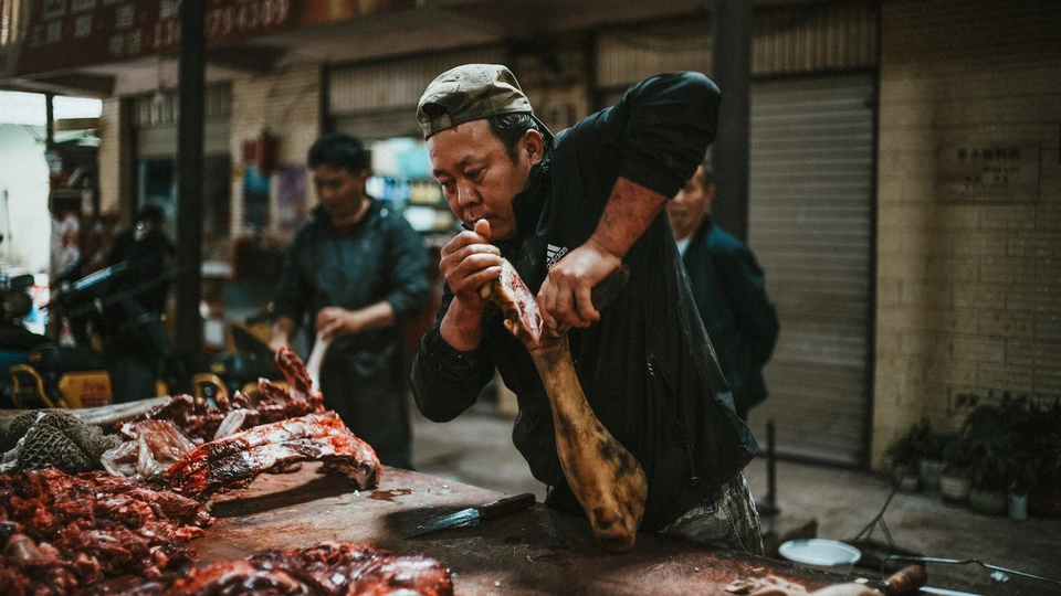 在市场上一名男子正在解剖一只死动物。