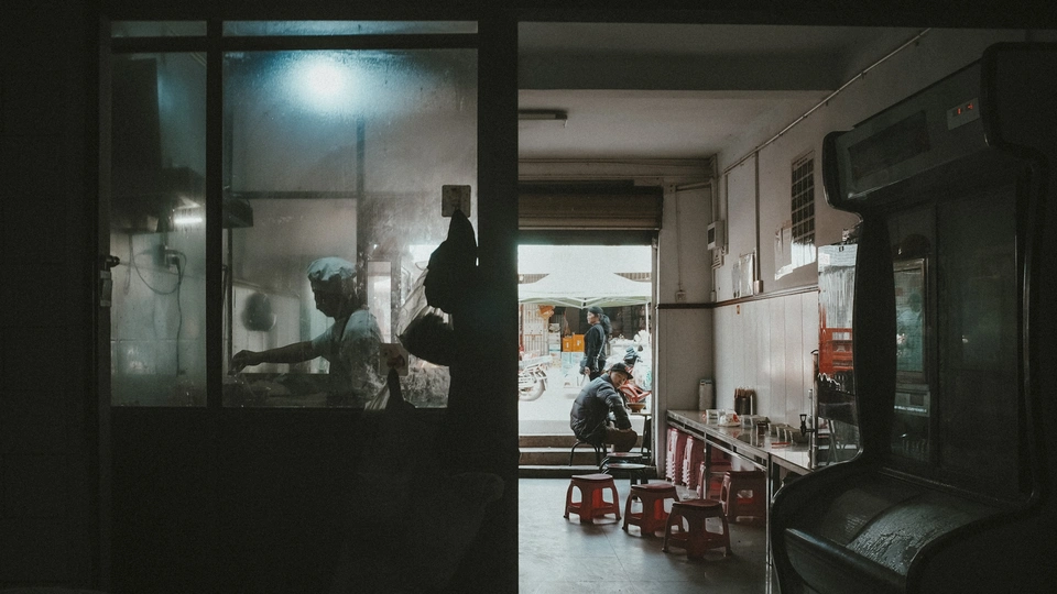 一个黑暗的房间 厨房里有人正在桌子旁准备食物。