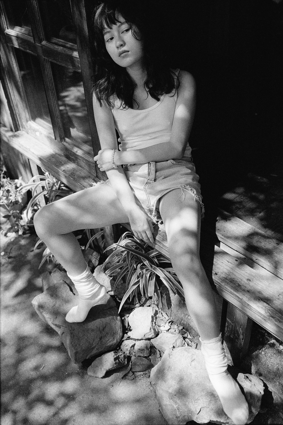 一张年轻女子坐在木凳上的黑白照片