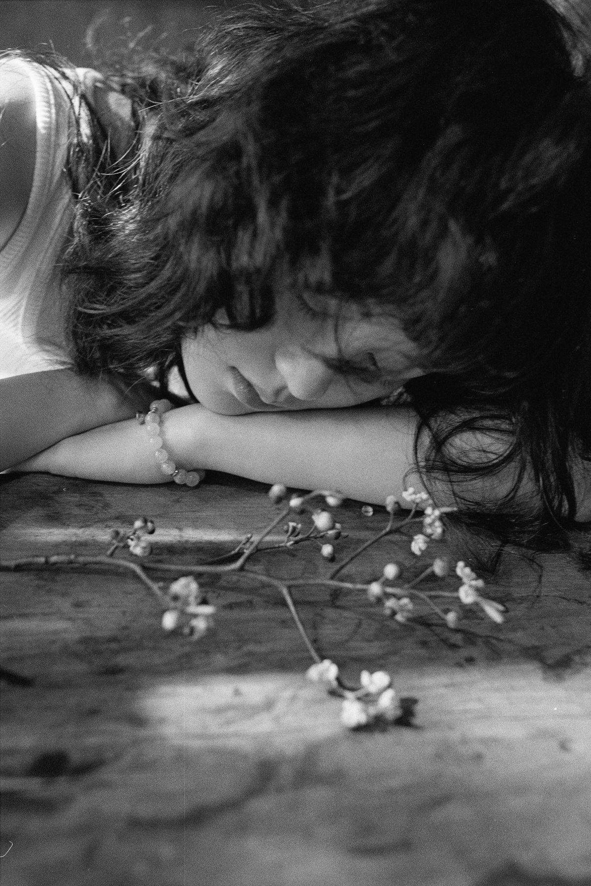一个小女孩双手抱头躺在地板上的黑白照片