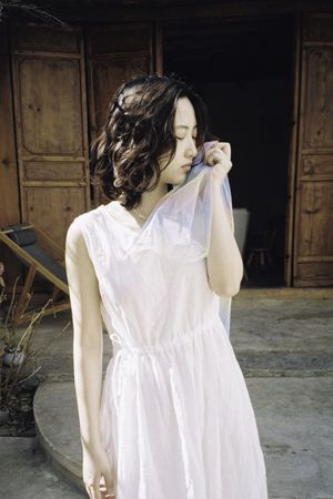 一个穿着白色连衣裙站在门口的模特
