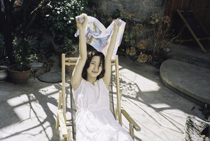 一个穿着白色连衣裙的年轻女子坐在椅子上抱着一个小女孩