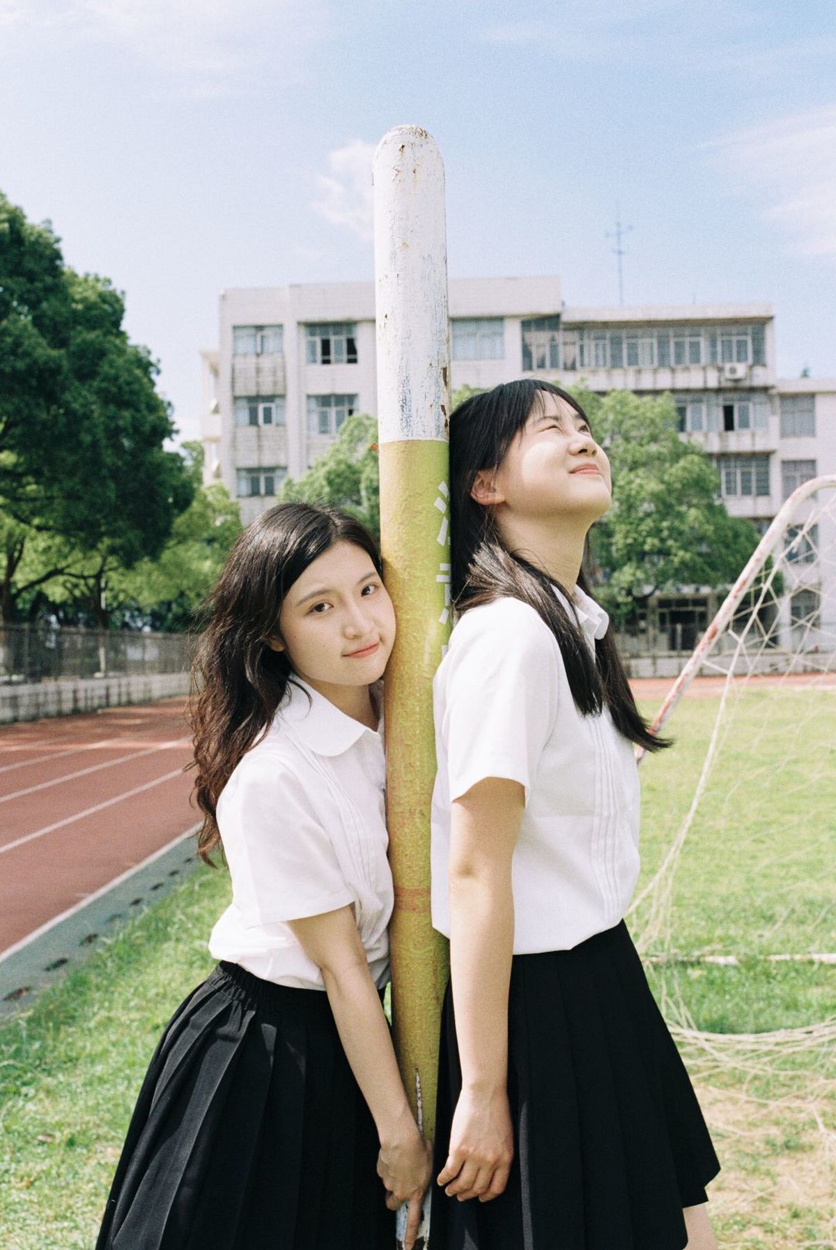 两个年轻女孩站在一根柱子旁边