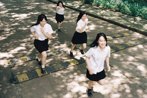 穿校服的年轻女子跑下人行道