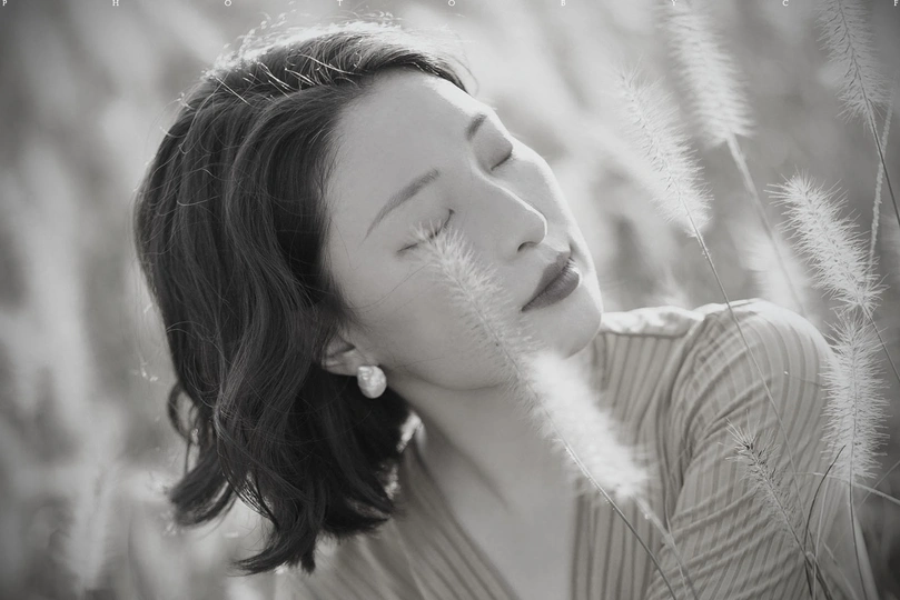 黑白肖像画 一位美丽的年轻女子闭着眼睛 在草地上。