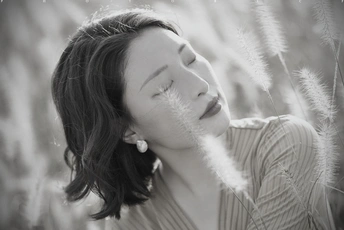 黑白肖像画 一位美丽的年轻女子闭着眼睛 在草地上。