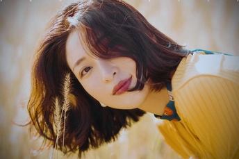 一位美丽的年轻女子穿着黄色连衣裙在田野中的肖像