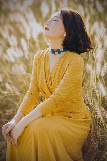 一位穿着黄色裙子的女人坐在田野里