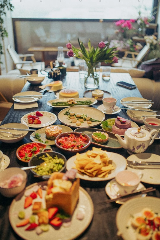 许多盘子和碗里装满了食物的漫长桌子