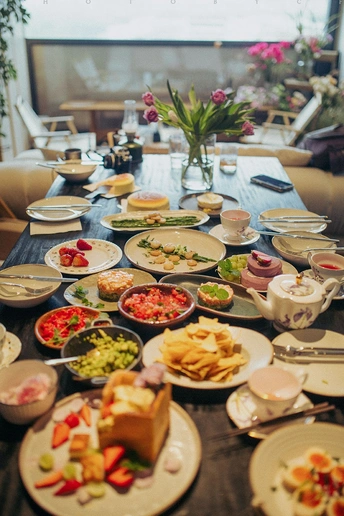 许多盘子和碗里装满了食物的漫长桌子