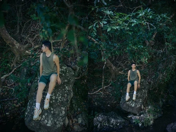 一些年轻人坐在森林中的一块岩石上 旁边有水。