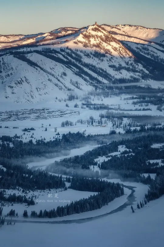 冬季一个白雪皑皑的山脉 背景中有河流和山脉。