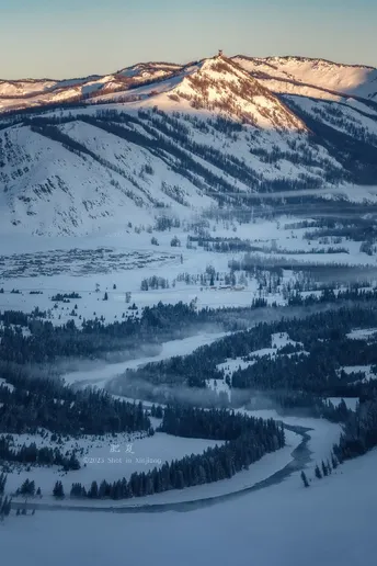 冬季一个白雪皑皑的山脉 背景中有河流和山脉。