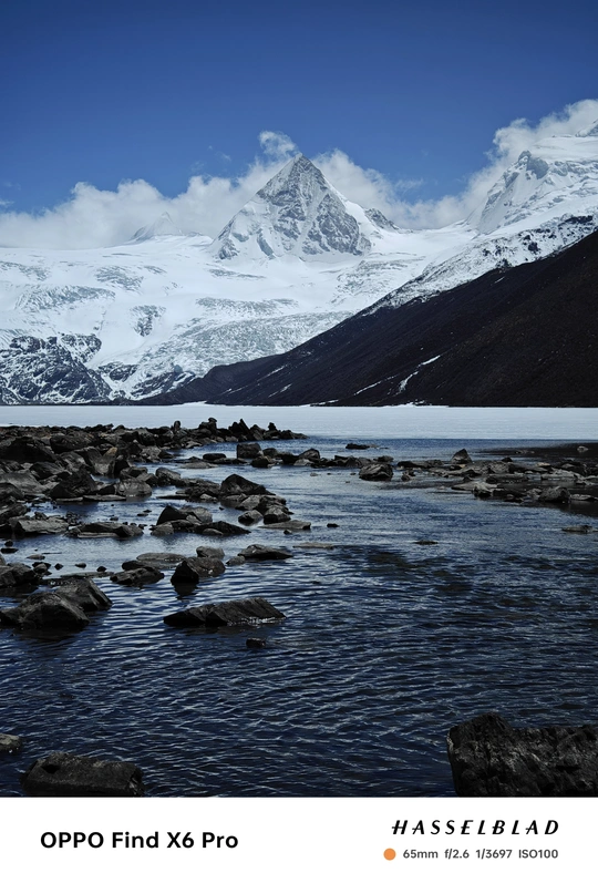 背景为有岩石和雪山的小河