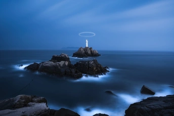 夜晚照亮海洋中央的一座岩石岛屿