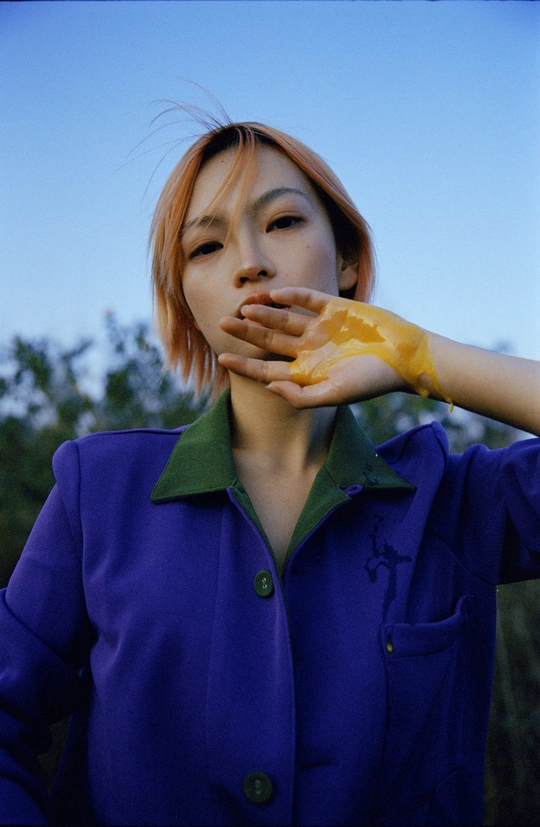 一位年轻女子穿着一件蓝色夹克 双手举到她面前