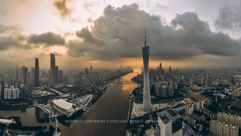 夕阳下的一座城市照片 有河流、摩天大楼和天空中的云彩。