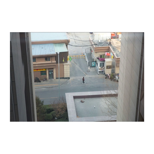 站在街边的建筑物的窗户向外看