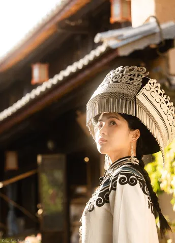 一位穿着中国传统服装的年轻女士戴着帽子站在一座寺庙前