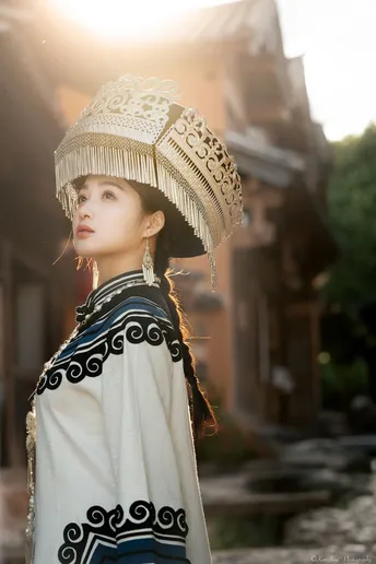 一位穿着传统服装的年轻女子戴着帽子站在街头的人物肖像