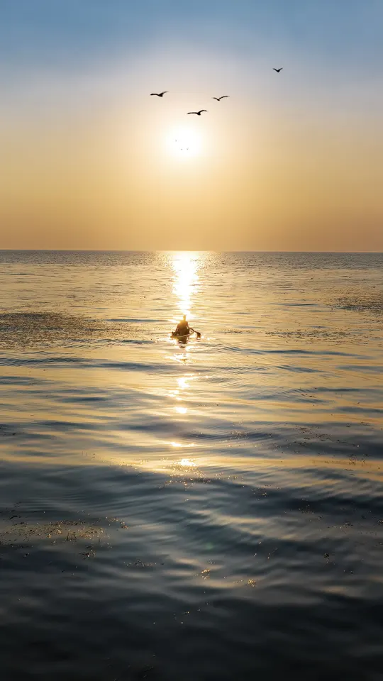 一艘漂浮在海洋上的船 当太阳落在一个水域上。