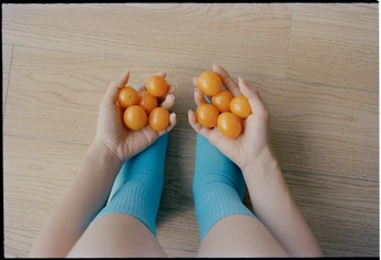 手里拿着桔子的人