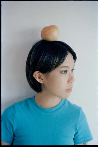 一位身穿蓝色衬衫、头发盘成发髻的年轻女子