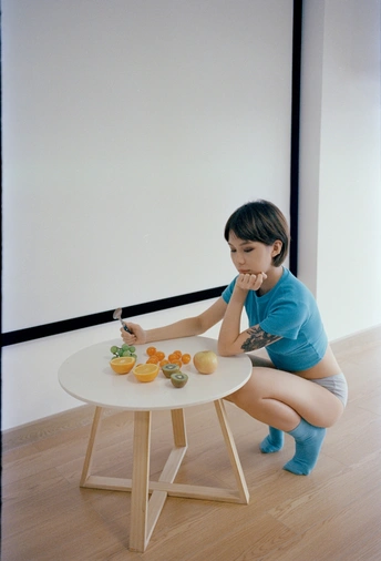 一个坐在小木桌旁吃东西的小女孩