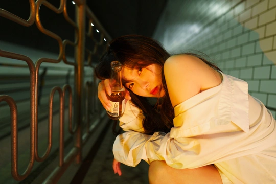一个穿着白色连衣裙的年轻女子拿着一杯葡萄酒