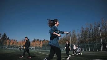 年轻女子在草地上踢足球