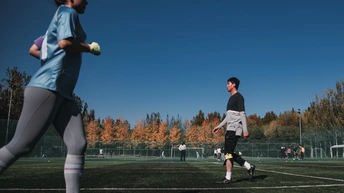 年轻男子在草地上踢足球