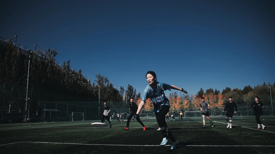夜晚在草地上踢足球的年轻男子