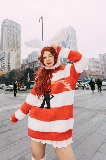 一位穿着红白相间服装的女性在街上摆姿势