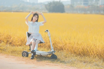 一个小女孩在草地上骑着一个小滑板车