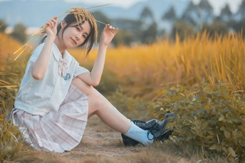 一位穿着裙子的女孩坐在田野里
