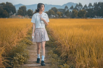 站在田野小径上的年轻女子