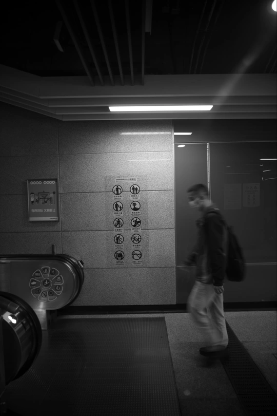 一个男子走进带有墙上的门的电梯